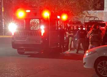 Ambulance with Flashing Red Lights on a Street at Night, a Crowd of People Behind Police Tape. - Adelante Mty