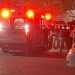 Ambulance with Flashing Red Lights on a Street at Night, a Crowd of People Behind Police Tape. - Adelante Mty