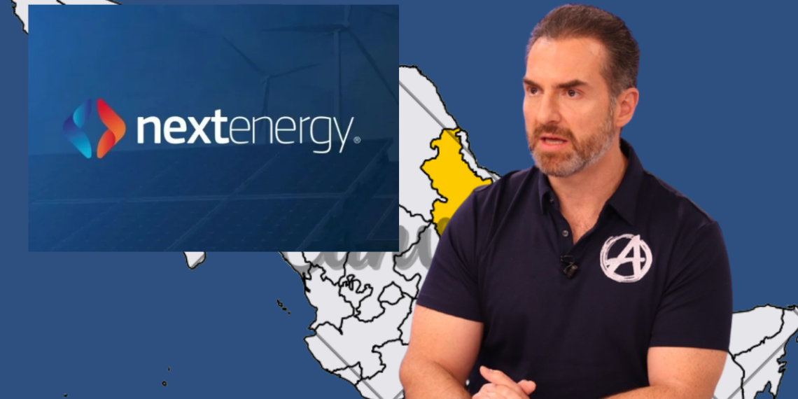 Speaker in a Black Polo with an Avengers Logo Presents Nextenergy Branding over a Blue Map Backdrop. - Adelante Mty