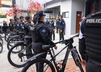 Line of Police Officers in Tactical Gear Standing with Their Bicycles Outside a Building. - Adelante Mty