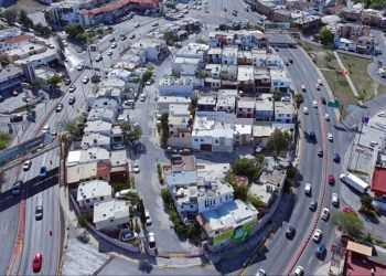 Aerial View of a Dense Urban Neighborhood with Curved Roads and White Buildings. - Adelante Mty