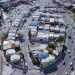Aerial View of a Dense Urban Neighborhood with Curved Roads and White Buildings. - Adelante Mty