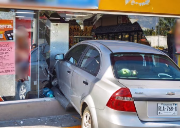 Silver Sedan Crashes into a Storefront, Breaking the Glass and Tearing Posters in the Window; Car License Plate Reads Rla-768-a. - Adelante Mty