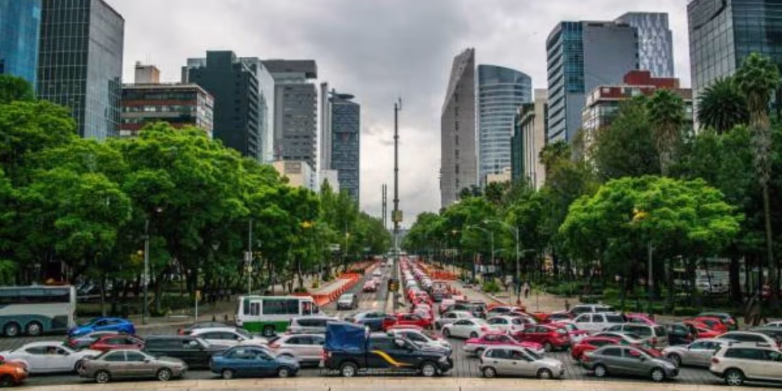 Desidam4fzfutdjlodrus6cvpqjpg - Adelante Mty Busy City Boulevard Lined with Green Trees and Tall Office Buildings, Heavy Traffic in Both Directions on a Cloudy Day. - Adelante Mty