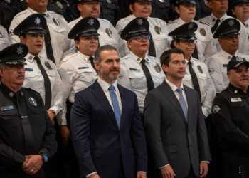 Two Men in Suits Stand in Front of a Line of Uniformed Police Officers at a Formal Event.", - Adelante Mty