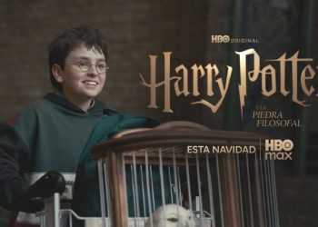 Boy with Glasses in a Green Hoodie Smiles While Pushing a Cart, in Front of a Harry Potter Promotional Backdrop with Hbo Max Branding. - Adelante Mty