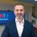 Images - Adelante Mty Man in a Dark Suit and White Shirt Speaks to the Camera in a Modern Briefing Room with Large Screens and Flags in the Background. - Adelante Mty