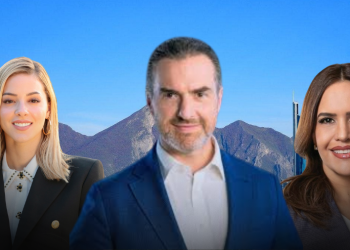 Three Business Professionals Posing Outdoors Against a Clear Blue Sky and Mountain Backdrop; a Blonde Woman in a Black Blazer, a Man in a Blue Suit, and a Brunette Woman in a Light Blazer Smile at the Camera. - Adelante Mty